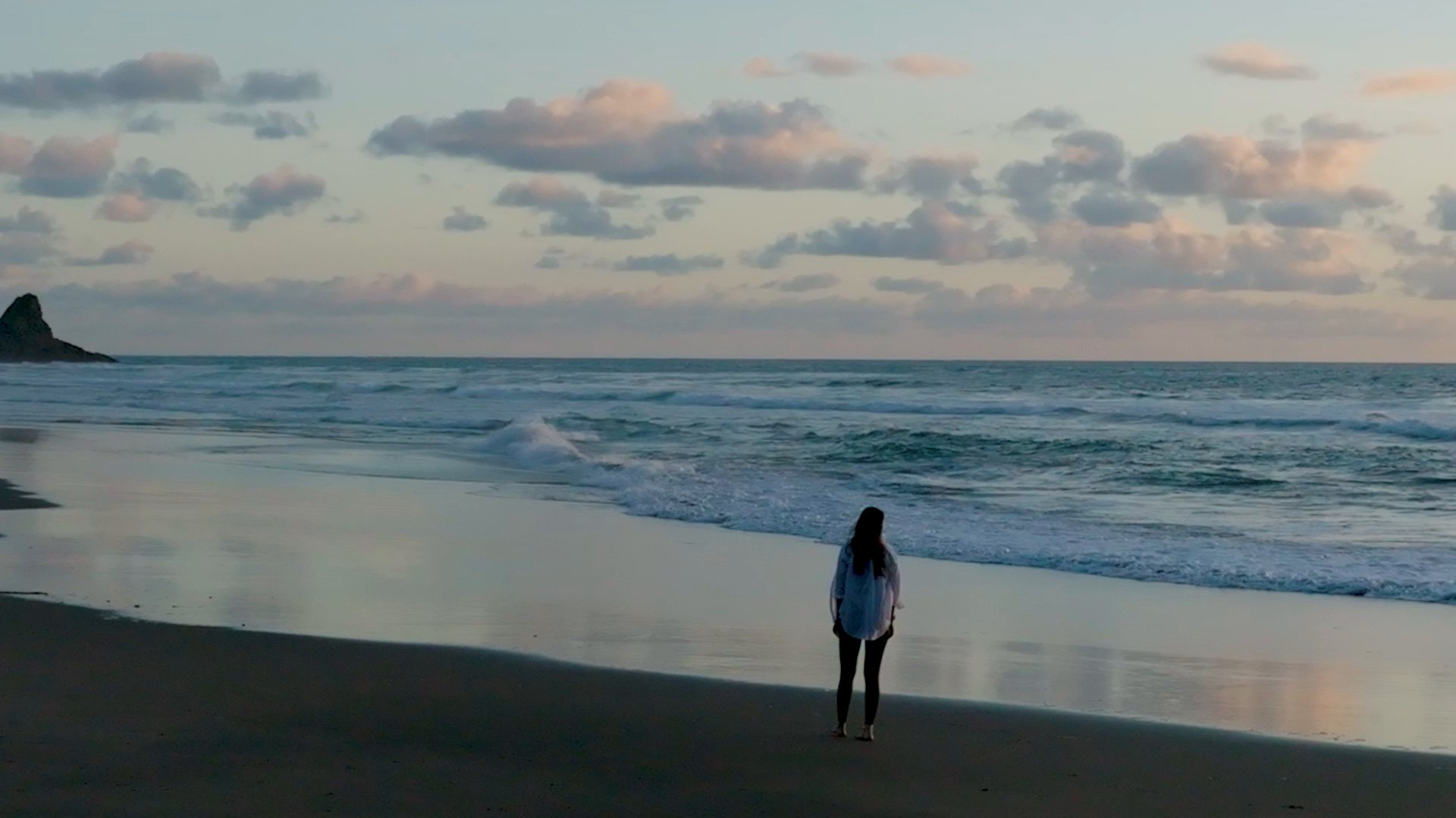 Andreea walking along the shoreline at dusk